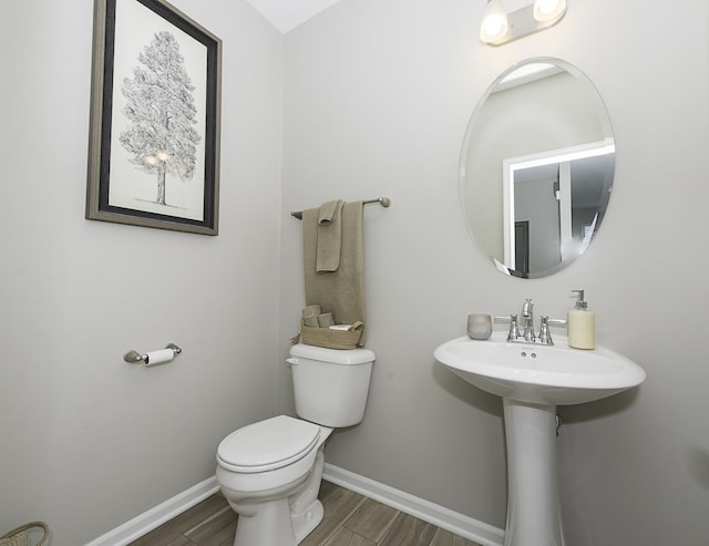 bathroom with toilet, wood-type flooring, and sink