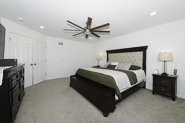 bedroom with ceiling fan, a closet, and light colored carpet