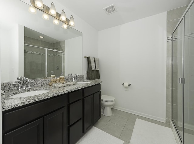 bathroom with vanity, toilet, tile patterned flooring, and an enclosed shower