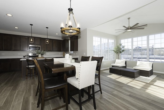 dining area featuring lofted ceiling, wood-type flooring, and ceiling fan with notable chandelier