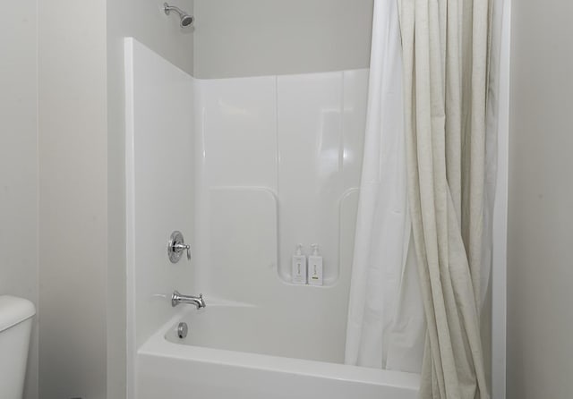 bathroom with toilet and shower / tub combo