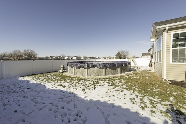 snowy yard featuring a covered pool