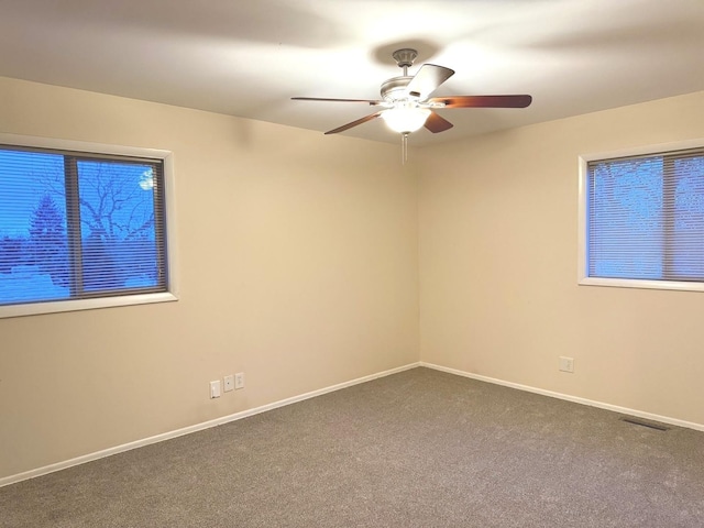 carpeted spare room featuring ceiling fan