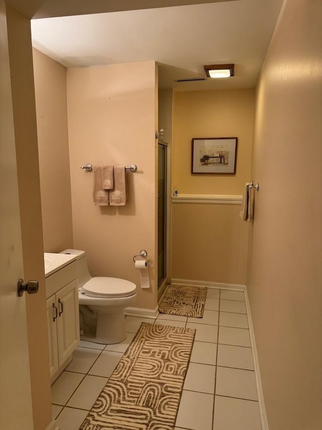 bathroom with toilet, vanity, tile patterned flooring, and an enclosed shower