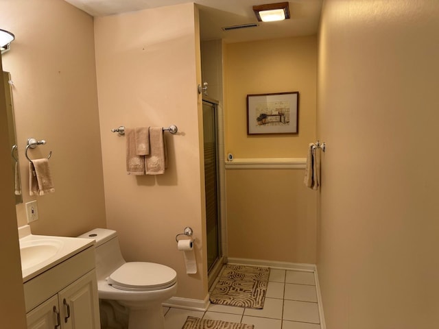 bathroom with toilet, tile patterned floors, vanity, and a shower with shower door