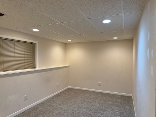 carpeted spare room featuring a paneled ceiling