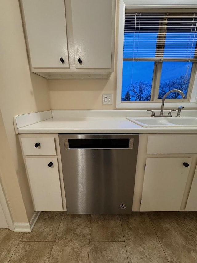 kitchen with stainless steel dishwasher, white cabinets, and sink