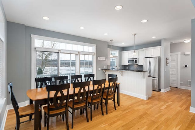 dining room featuring a wealth of natural light and light hardwood / wood-style flooring