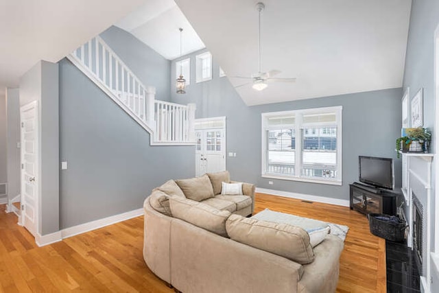 living room featuring ceiling fan, a wealth of natural light, hardwood / wood-style flooring, and high vaulted ceiling