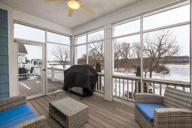 sunroom featuring ceiling fan and plenty of natural light