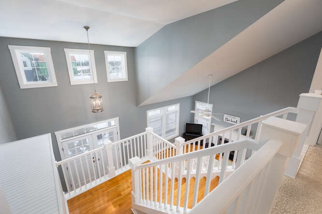 stairs with hardwood / wood-style flooring and vaulted ceiling