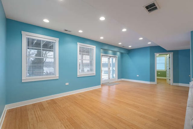 spare room featuring a healthy amount of sunlight and light hardwood / wood-style floors