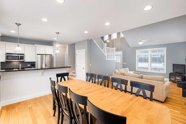 dining space featuring lofted ceiling, ceiling fan, a healthy amount of sunlight, and light hardwood / wood-style flooring