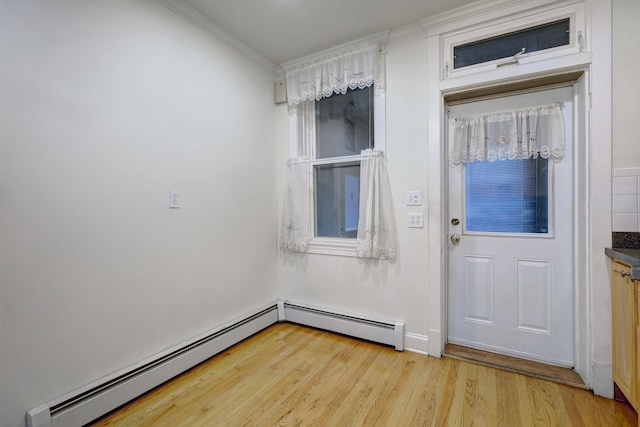 doorway featuring baseboard heating, ornamental molding, and light hardwood / wood-style flooring