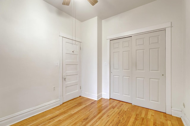 unfurnished bedroom with ceiling fan, a closet, and light wood-type flooring