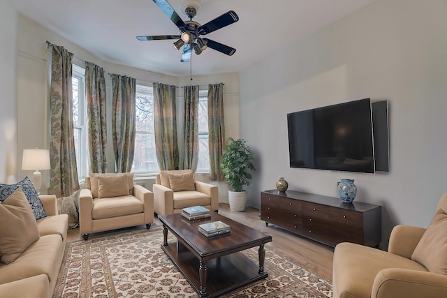 living room with light hardwood / wood-style floors and ceiling fan