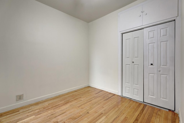 unfurnished bedroom with a closet and light hardwood / wood-style flooring