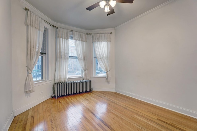 spare room with ceiling fan, radiator heating unit, ornamental molding, and light hardwood / wood-style floors