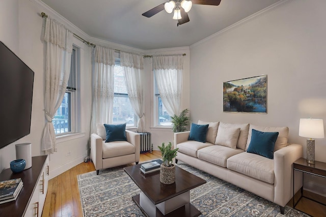 living room featuring hardwood / wood-style flooring, crown molding, and ceiling fan