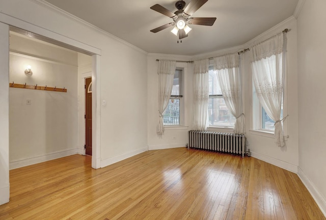 spare room with ceiling fan, radiator, crown molding, and light hardwood / wood-style flooring