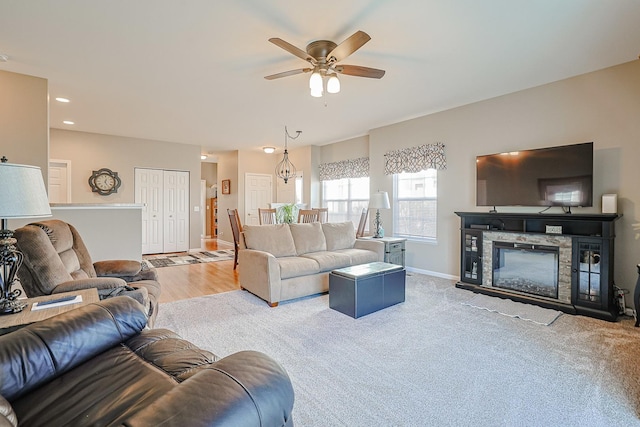 living room featuring ceiling fan, carpet, and a fireplace