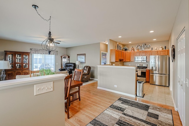 kitchen with light hardwood / wood-style floors, a chandelier, and appliances with stainless steel finishes