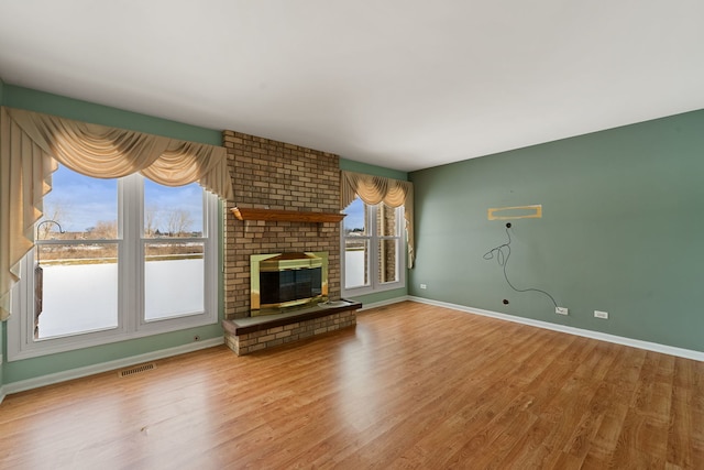 unfurnished living room with a brick fireplace and wood-type flooring