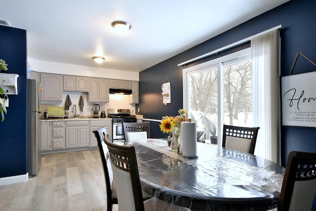 dining room featuring sink and light wood-type flooring