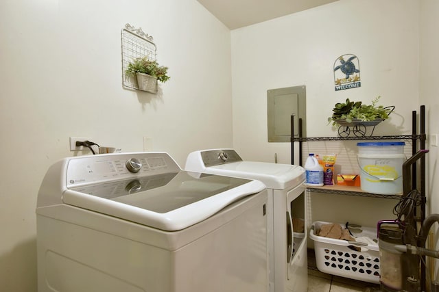 laundry area featuring electric panel, tile patterned flooring, and washer and clothes dryer