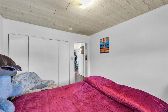 bedroom with wood ceiling, white fridge, and a closet