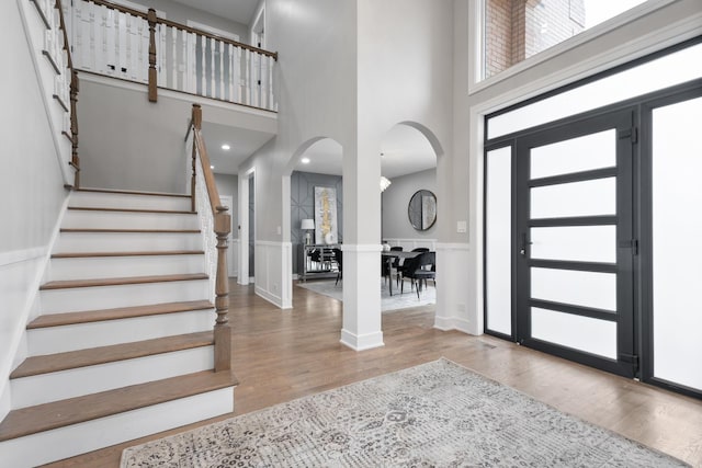 entryway featuring hardwood / wood-style flooring, a towering ceiling, and plenty of natural light