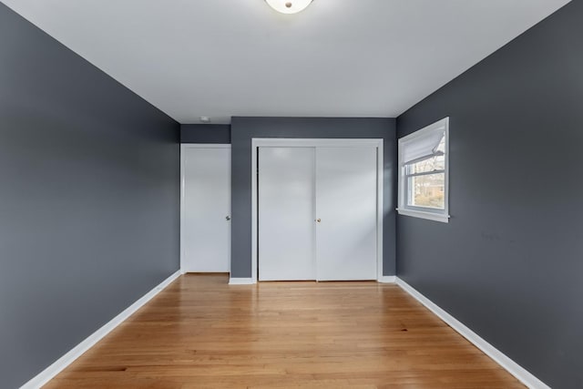 unfurnished bedroom featuring light wood-type flooring and a closet