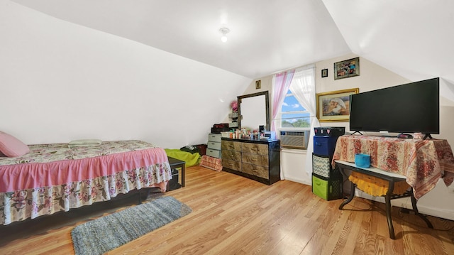 bedroom featuring cooling unit, vaulted ceiling, and light wood-type flooring