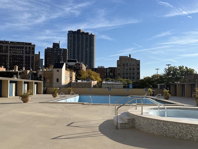 view of pool with a jacuzzi and a patio area