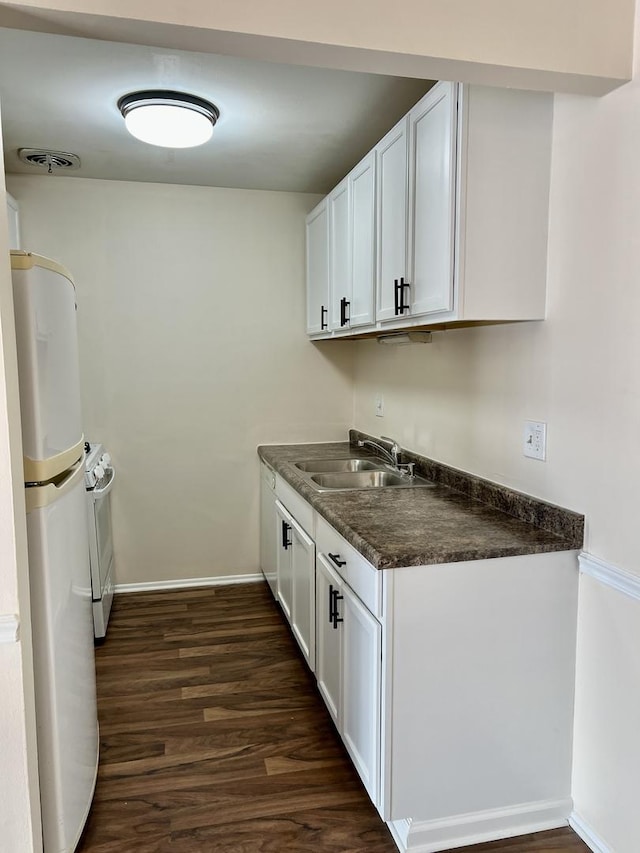 kitchen with white cabinetry, refrigerator, dark hardwood / wood-style flooring, and sink