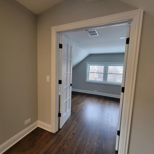 corridor with lofted ceiling and dark hardwood / wood-style floors