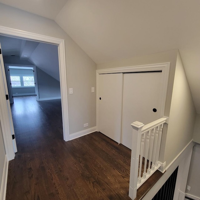 hallway featuring dark hardwood / wood-style floors and lofted ceiling