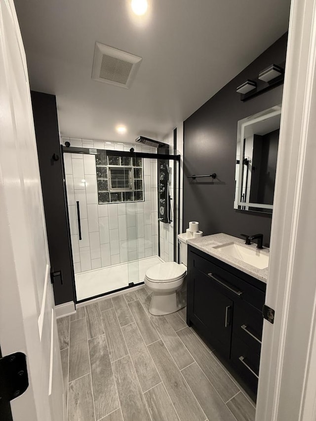 bathroom with toilet, vanity, and walk in shower