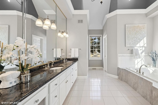 bathroom featuring vanity, tiled bath, and tile patterned floors