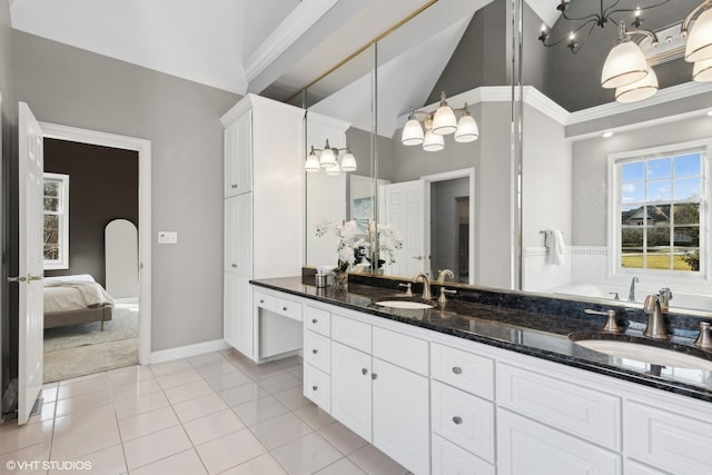 bathroom featuring tile patterned flooring, vaulted ceiling, and vanity