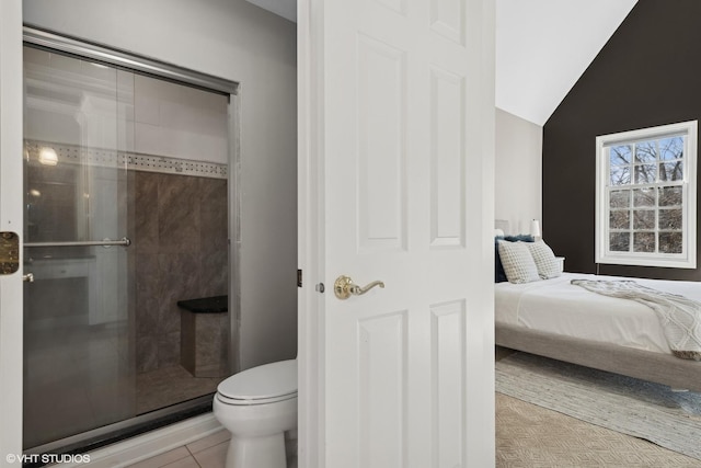 bathroom with a shower with door, vaulted ceiling, tile patterned floors, and toilet