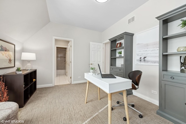 carpeted office space featuring vaulted ceiling