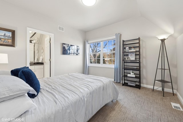 carpeted bedroom with lofted ceiling and ensuite bath