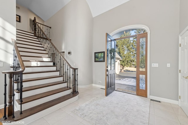 tiled foyer entrance featuring high vaulted ceiling