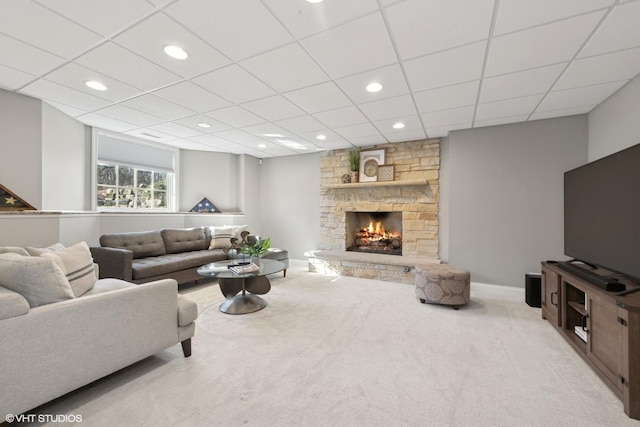 carpeted living room featuring a stone fireplace