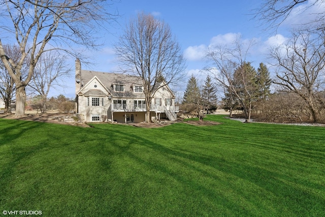 rear view of property with a yard and a deck