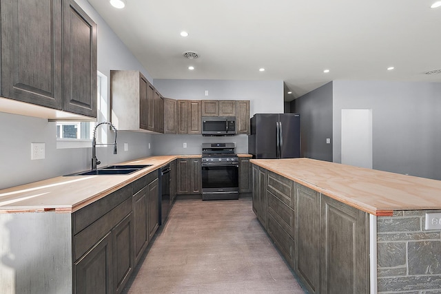 kitchen featuring sink, butcher block countertops, black appliances, and dark brown cabinets