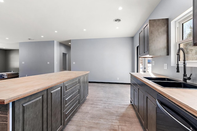 kitchen with wooden counters, black dishwasher, light hardwood / wood-style floors, sink, and dark brown cabinets