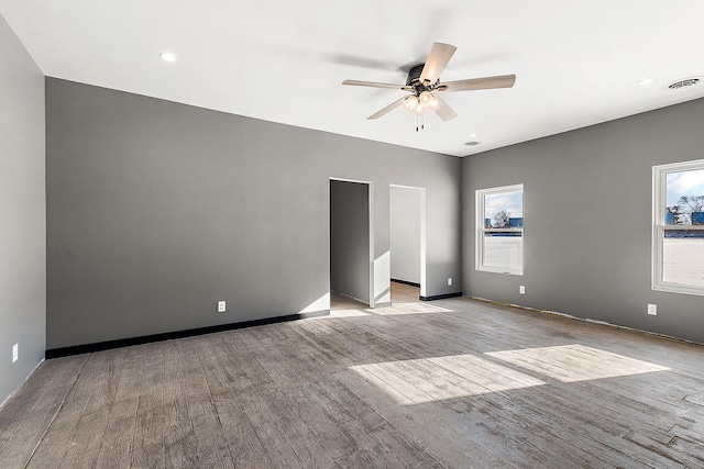 spare room with ceiling fan, a wealth of natural light, and light hardwood / wood-style floors