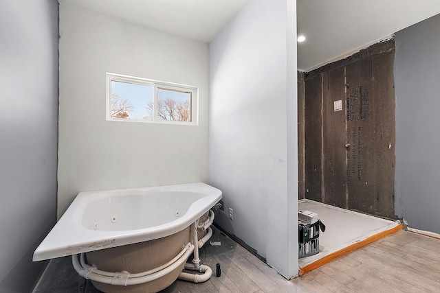 bathroom with a bathtub and hardwood / wood-style flooring